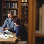 Mature students working together in college library